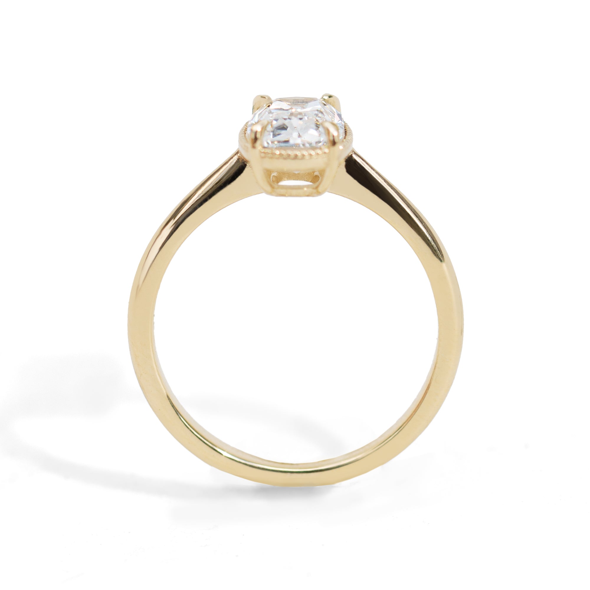 Gold milgrain ring with a 1.5 carat old mine cut diamond on a white background