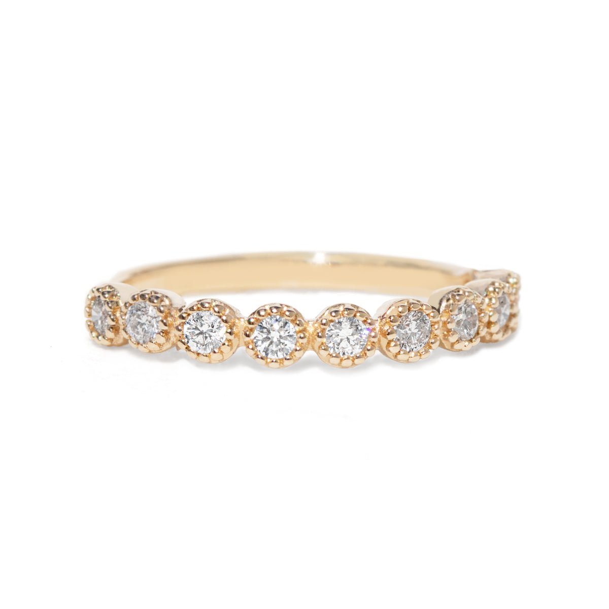 Gold ring with ten diamonds on a white background with beaded setting