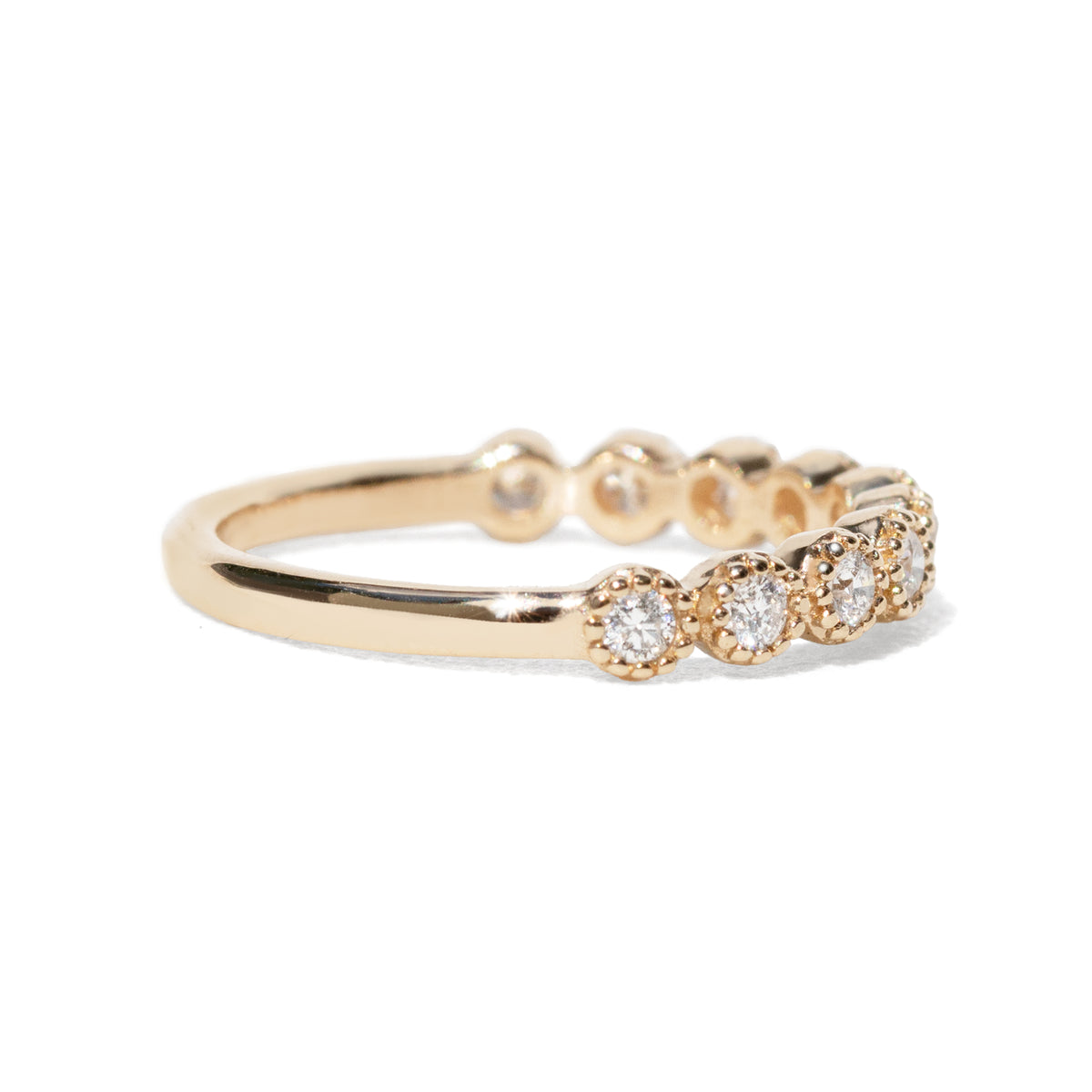 Gold ring with ten diamonds on a white background with beaded setting
