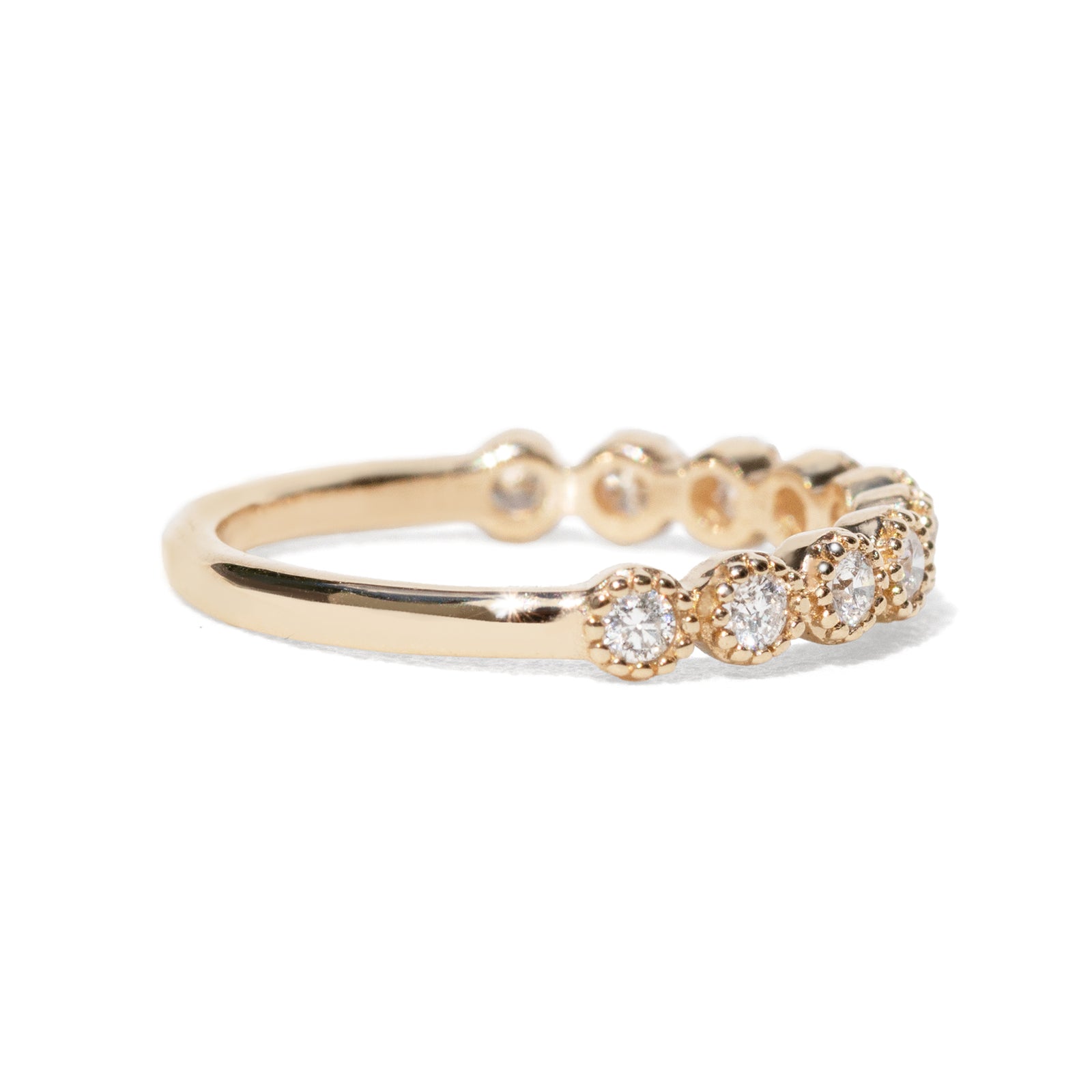 Gold ring with ten diamonds on a white background with beaded setting