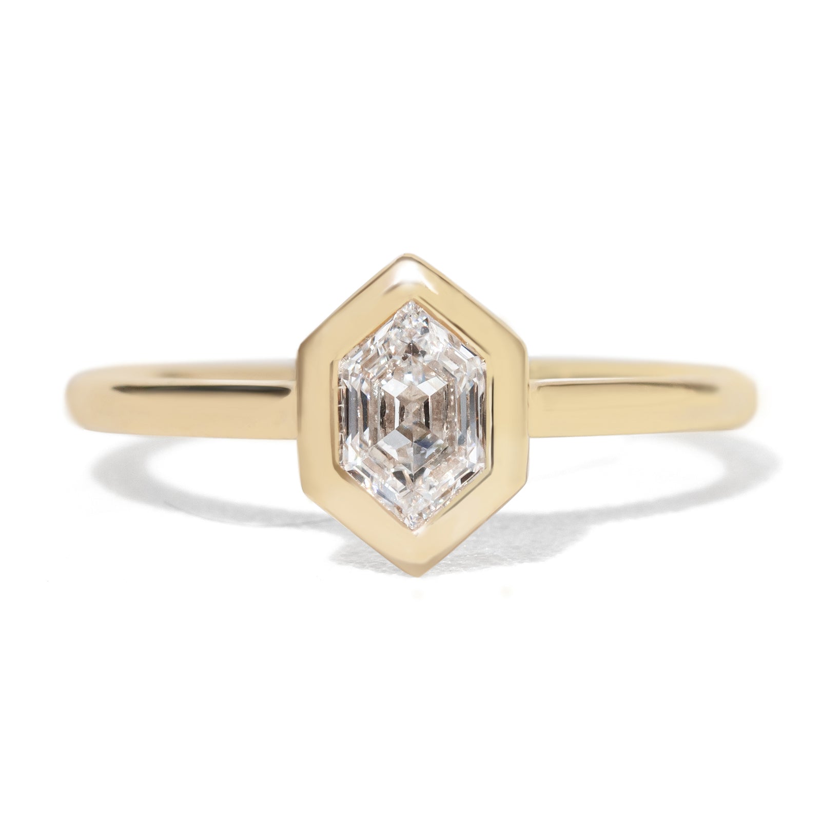 Gold  bezel ring with a hexagon diamond gemstone  stone on a white background