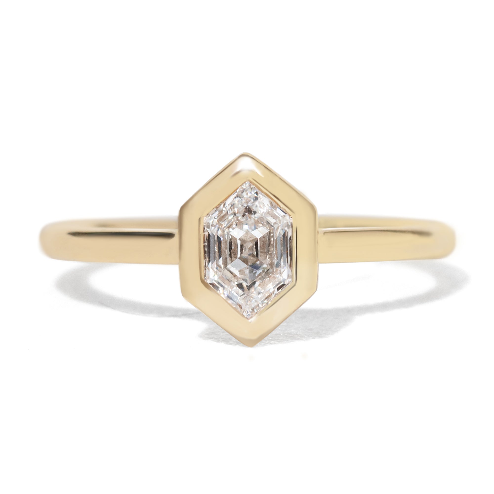Gold  bezel ring with a hexagon diamond gemstone  stone on a white background