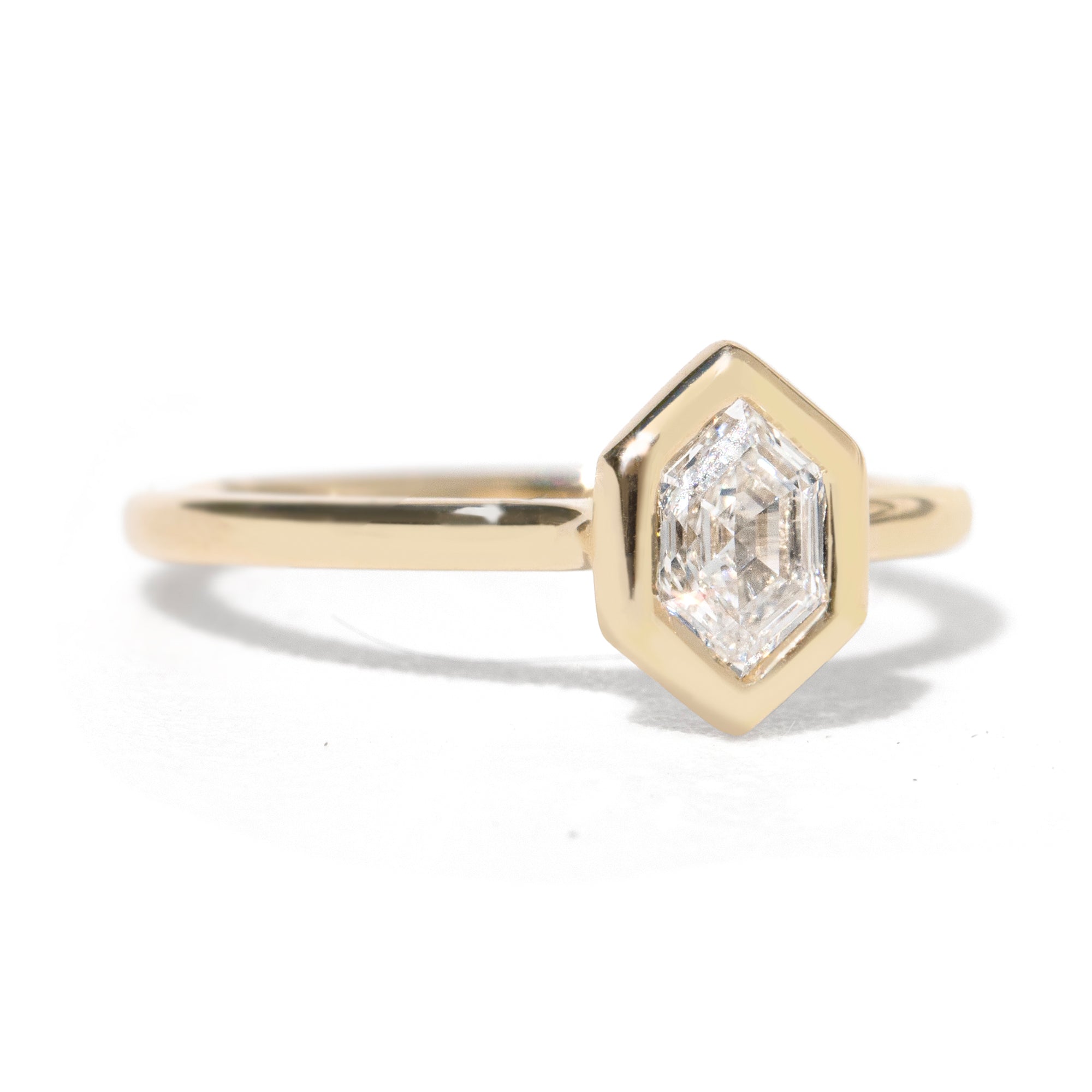 Gold  bezel ring with a hexagon diamond gemstone  stone on a white background