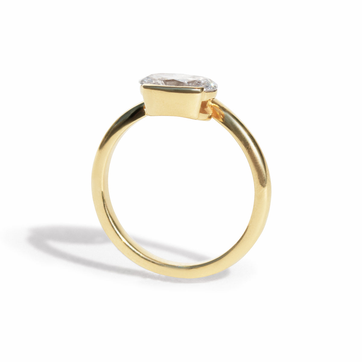 The Flow Ring features a 1 carat oval diamond or moissanite in a half bezel setting. The east west design adds a unique touch to this minimalistic design, making it the perfect subtle statement ring.