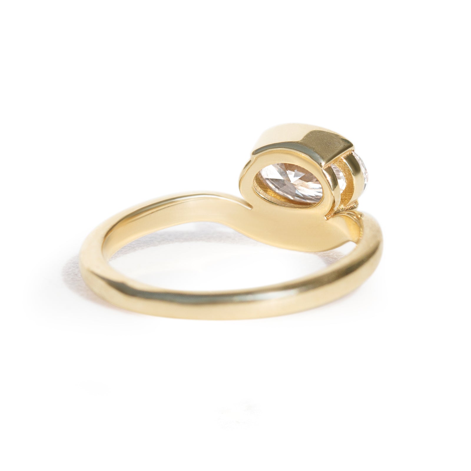 The Flow Ring features a 1 carat oval diamond or moissanite in a half bezel setting. The east west design adds a unique touch to this minimalistic design, making it the perfect subtle statement ring.