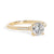 Gold ring with a large diamond and smaller diamonds on the band against a white background