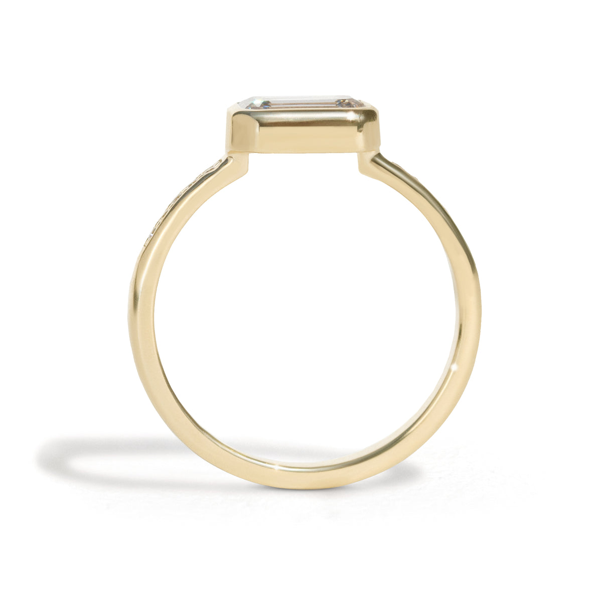 The Zoey Ring features a 1-carat emerald-cut diamond or moissanite in an east-west setting. The smooth bezel setting ensures everyday wear, while delicate accent diamonds add sparkle from every angle