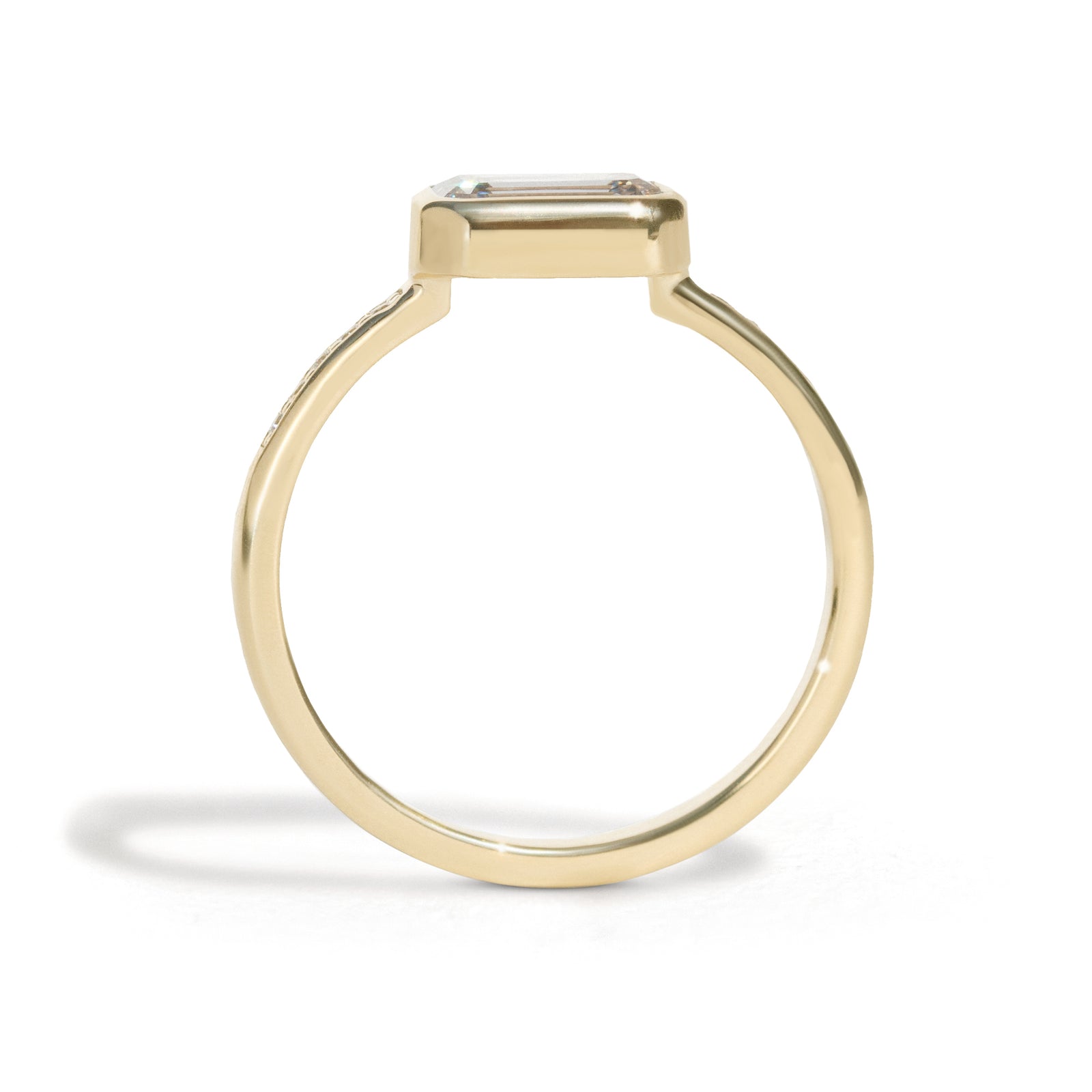 The Zoey Ring features a 1-carat emerald-cut diamond or moissanite in an east-west setting. The smooth bezel setting ensures everyday wear, while delicate accent diamonds add sparkle from every angle