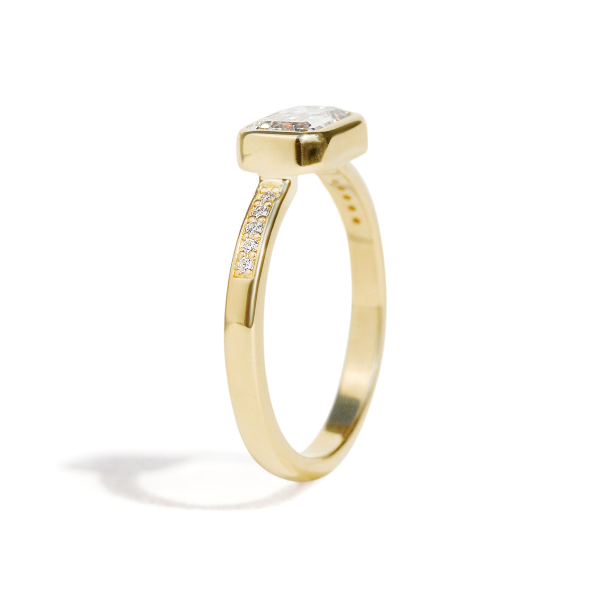 The Zoey Ring features a 1-carat emerald-cut diamond or moissanite in an east-west setting. The smooth bezel setting ensures everyday wear, while delicate accent diamonds add sparkle from every angle