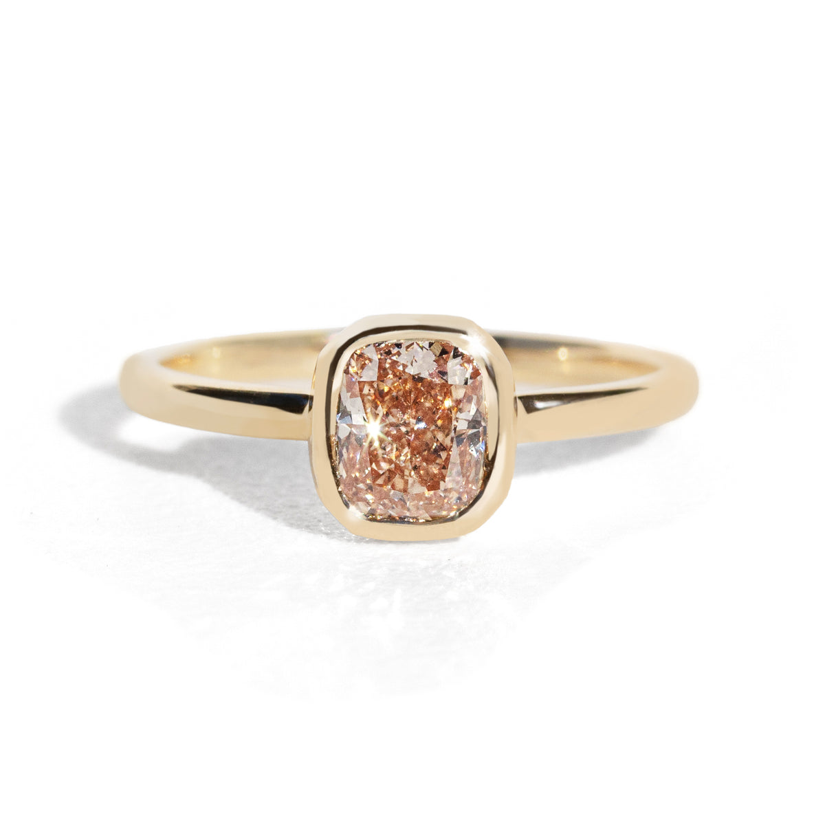 Gold ring with a brown diamond on a white background