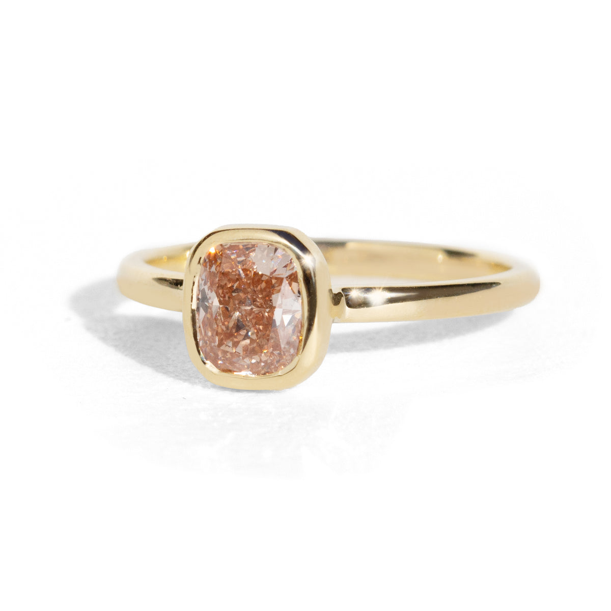 Gold ring with a pinkish-brown diamond on a white background