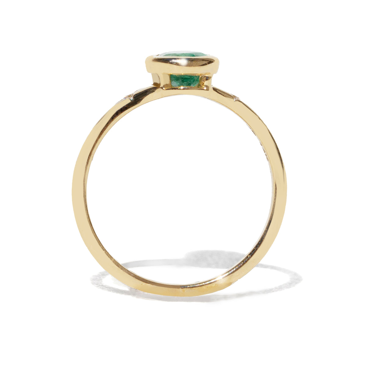 Gold ring with a green gemstone on a white background
