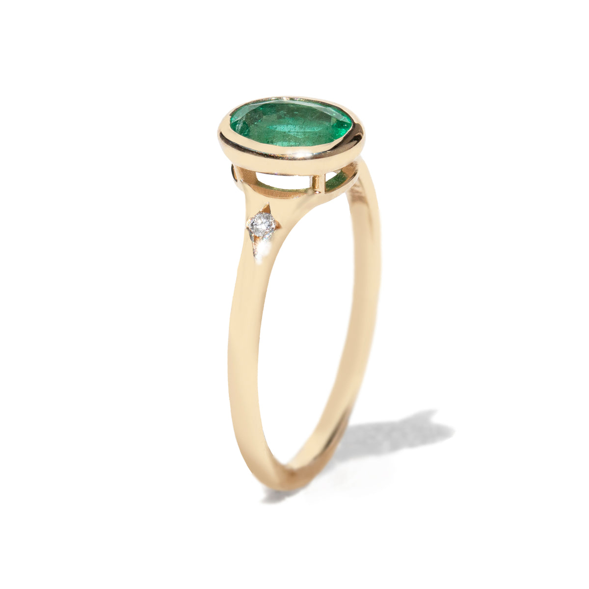 Gold ring with a green gemstone on a white background