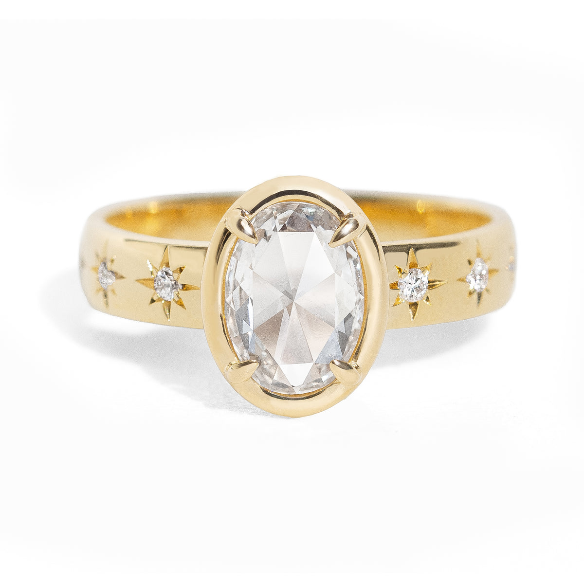 Gold ring with a large oval rose cut diamond and smaller diamonds on the band against a white background