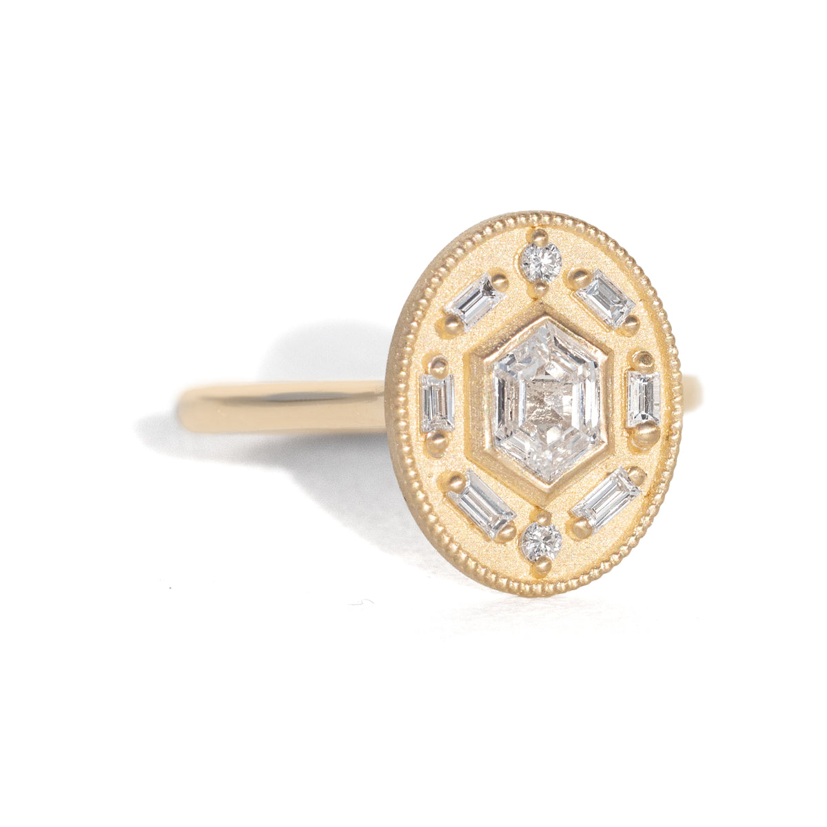 Gold ring with diamond accents around a hexagon diamond in the center on a white background