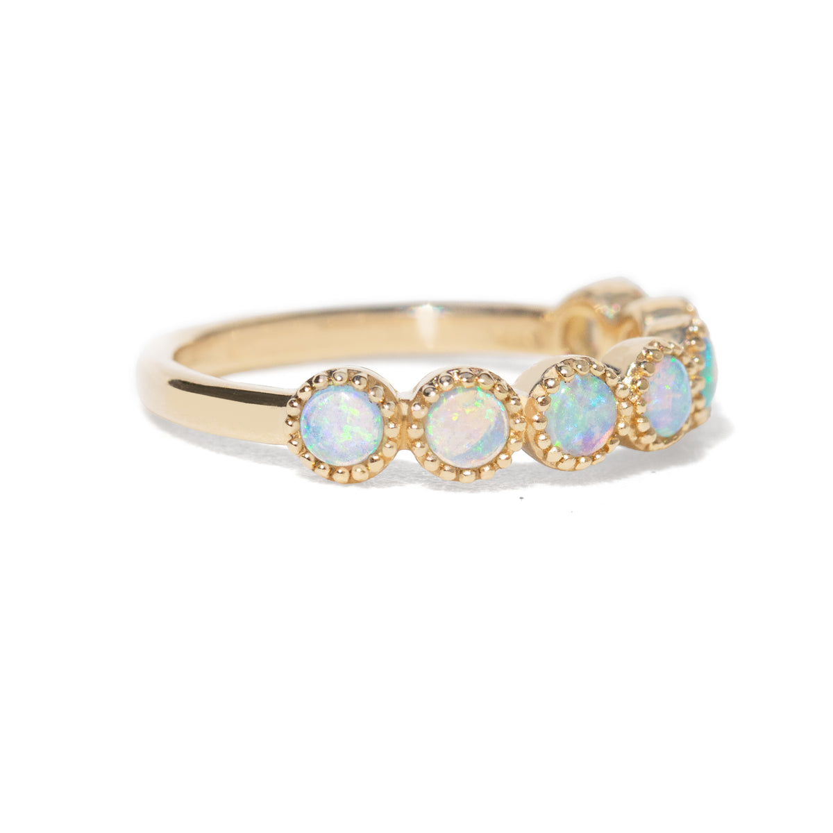 Yellow gold ring with seven round opals on white background  