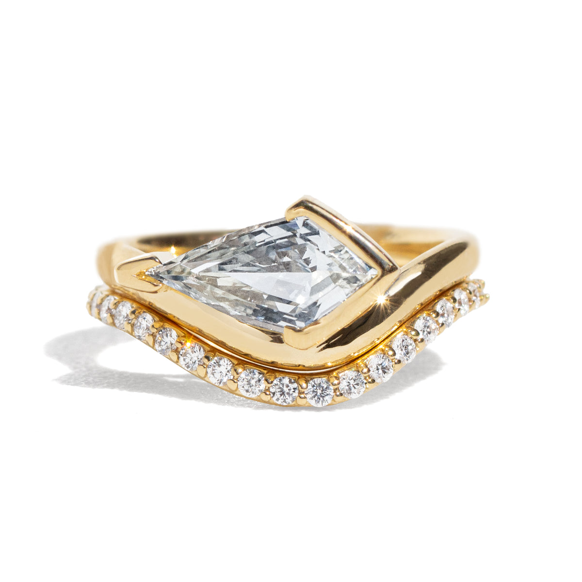 A light blue sapphrie ring and a diamond band on a white background