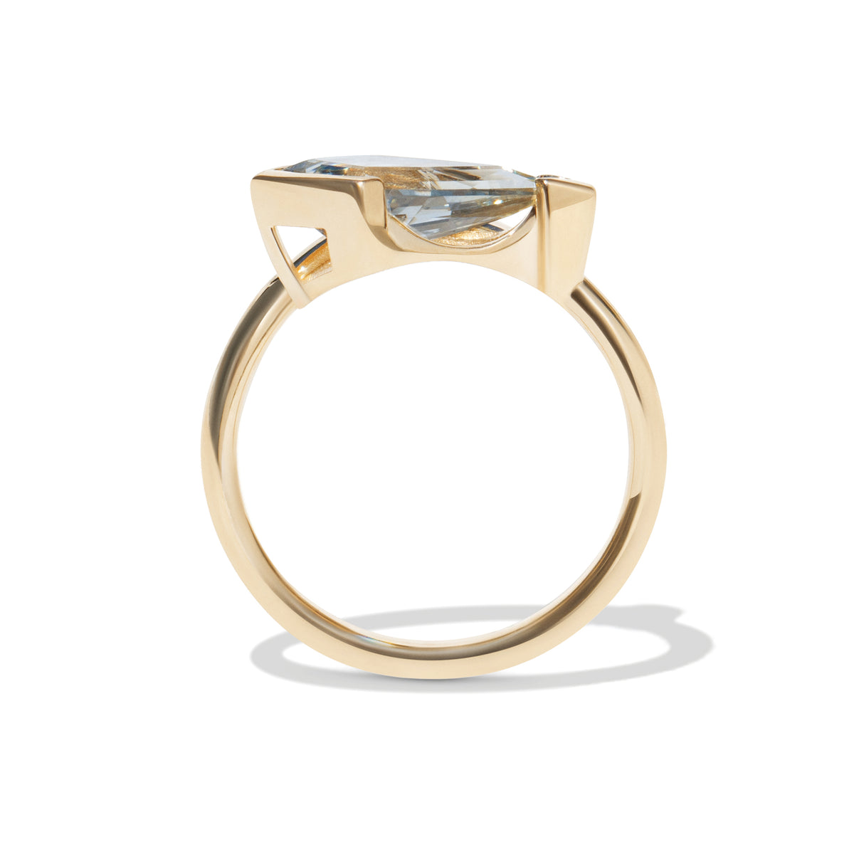 Gold ring with a light blue gemstone on a white background