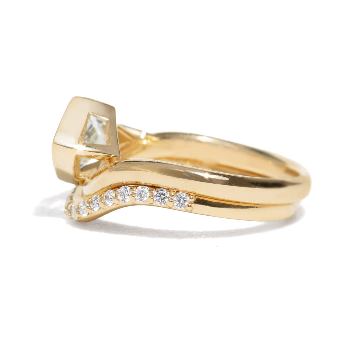Gold ring with a large light blue sapphire and smaller diamonds on the band against a white background