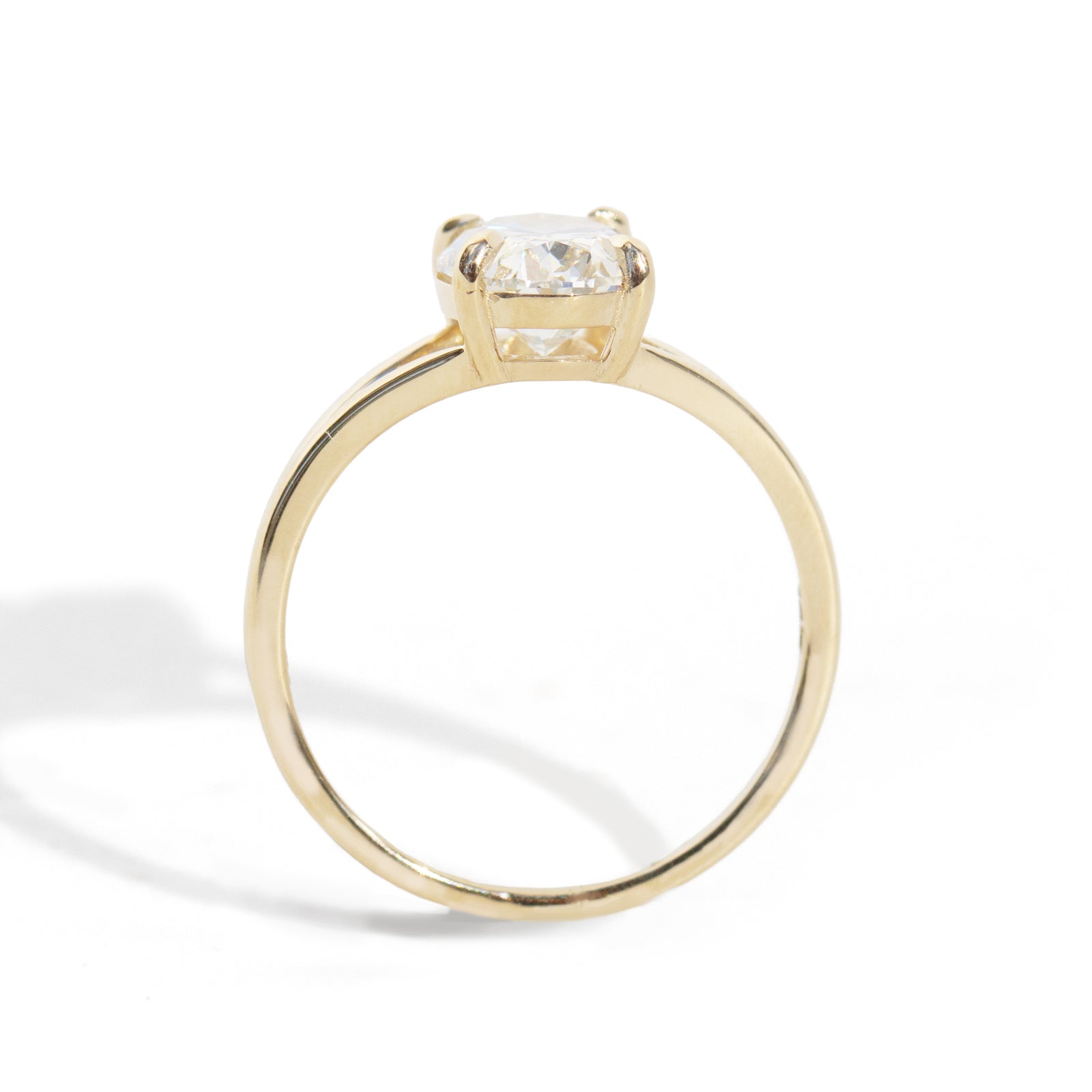 Gold ring with a clear gemstone on a white background