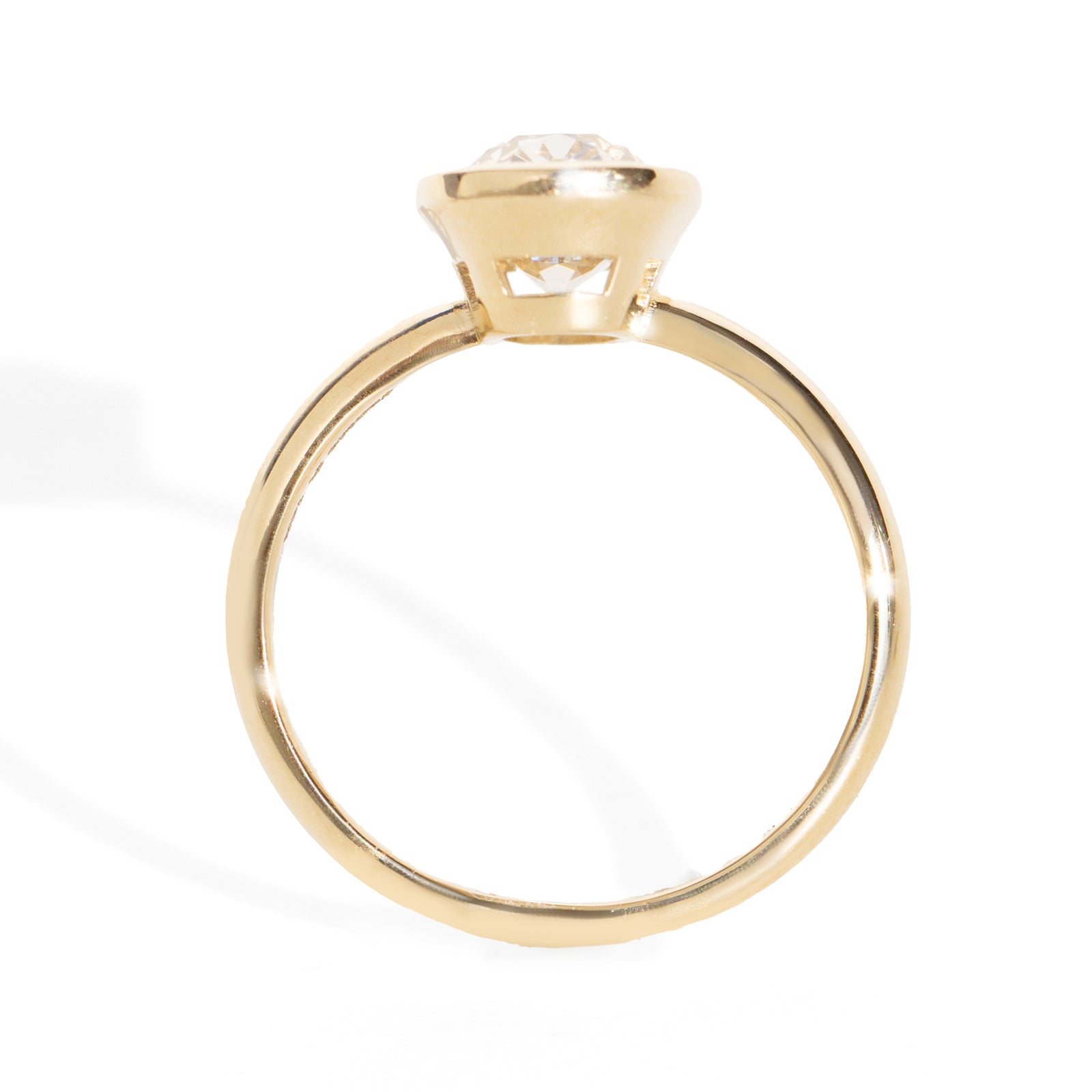 Gold bezel ring with a 2.6ct  old mine cut diamond on a white background