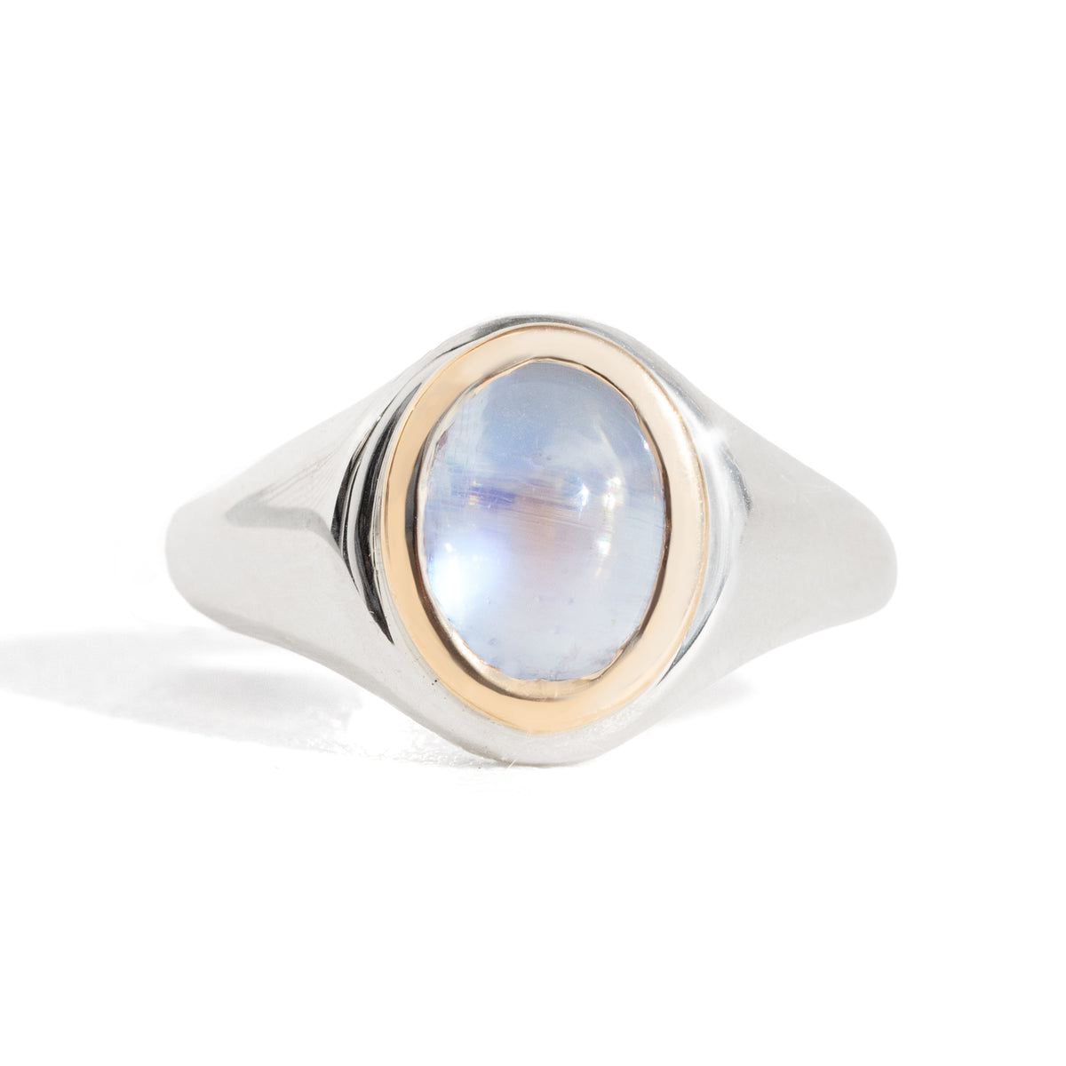 Ring with a blue moonstone and gold bezel setting on a silver band against a white background