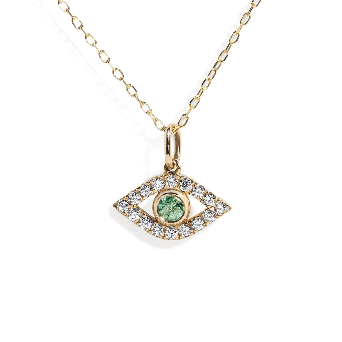 Gold eye charm with a green sapphire in the center surrounded by white diamond frame on a gold chain against white background. 