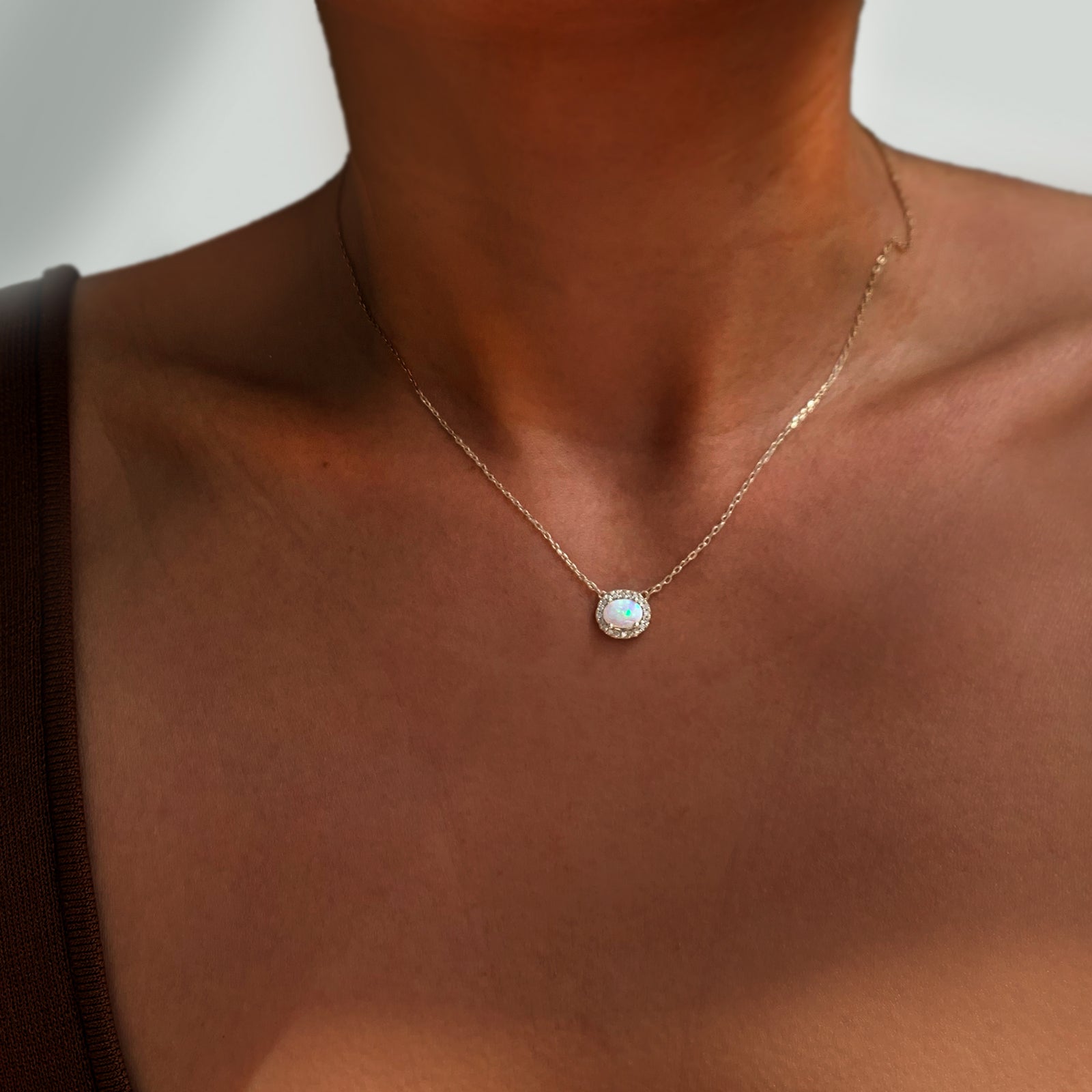 Jamie Park Jewelry -Opal Diamond Halo Necklace This necklace is the epitome of luxury, featuring an oval Australian opal surrounded by a radiant halo of natural diamonds. A symbol of hope and purity, it makes the perfect gift for any special occasion.