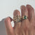 hand wearing multiple gold rings on white background