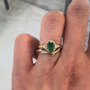 two gold rings on a hand against a gray background