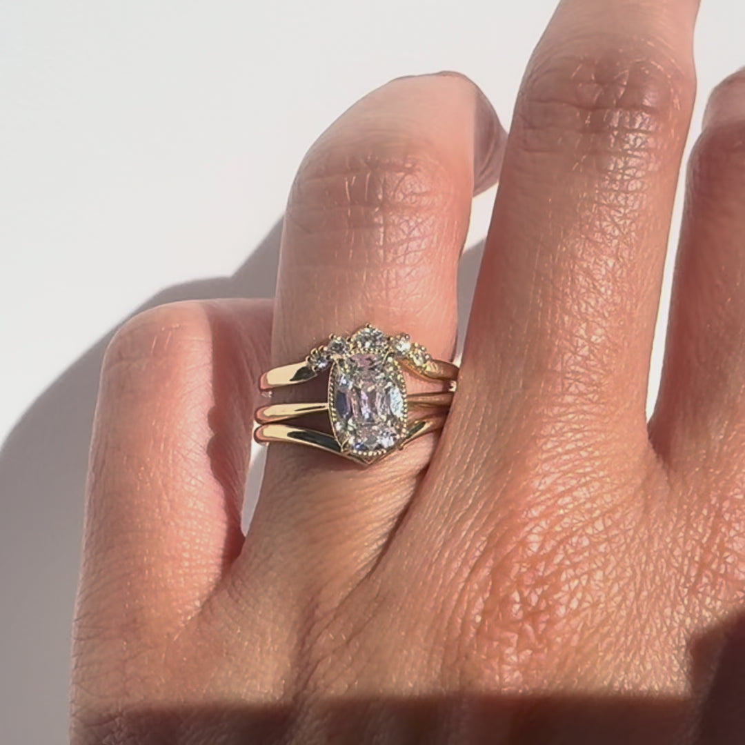 Old mine cut diamond ring  and two gold bands on a hand against  white background. 