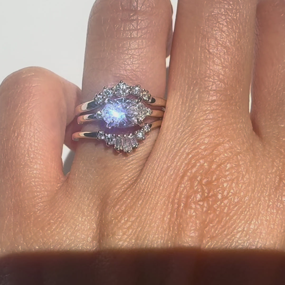 three diamond rings stacked together on a hand against a white background