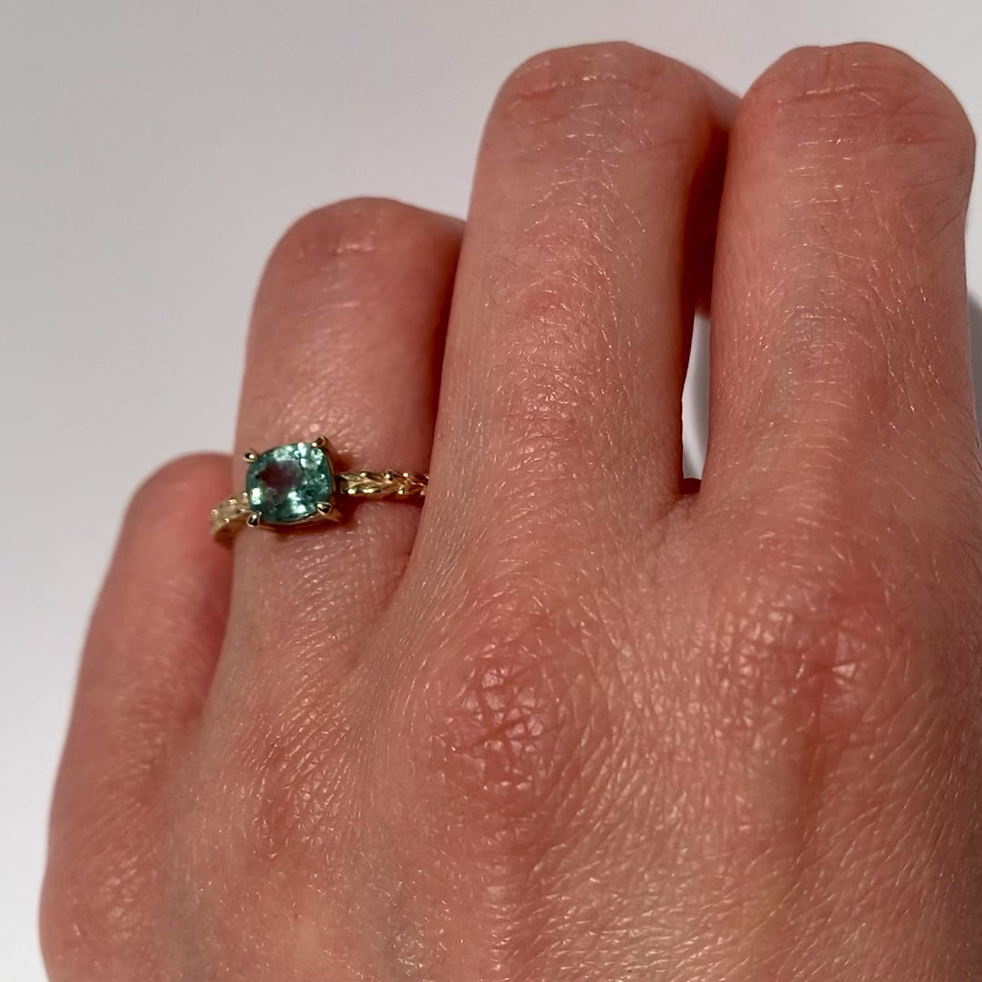 Jamie Park Jewelry -Meadow 1.16ct Cushion Montana Sapphire Ring Indulge in the beauty of nature with our Meadow Montana Sapphire Ring. Featuring a 1.16ct cushion cut sapphire, east-west set on an olive leaf band, this piece is perfect for an engagement ring or a special gift. The Montana sapphire's blue and green hues make it a truly one-of-a-kind piece to celebrate life's special moments.