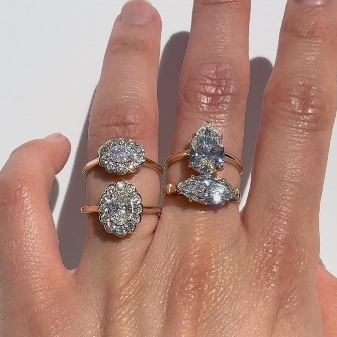 Four diamond rings on a hand against white background.
