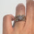Gold rings with diamond stacked on a finger against a white background