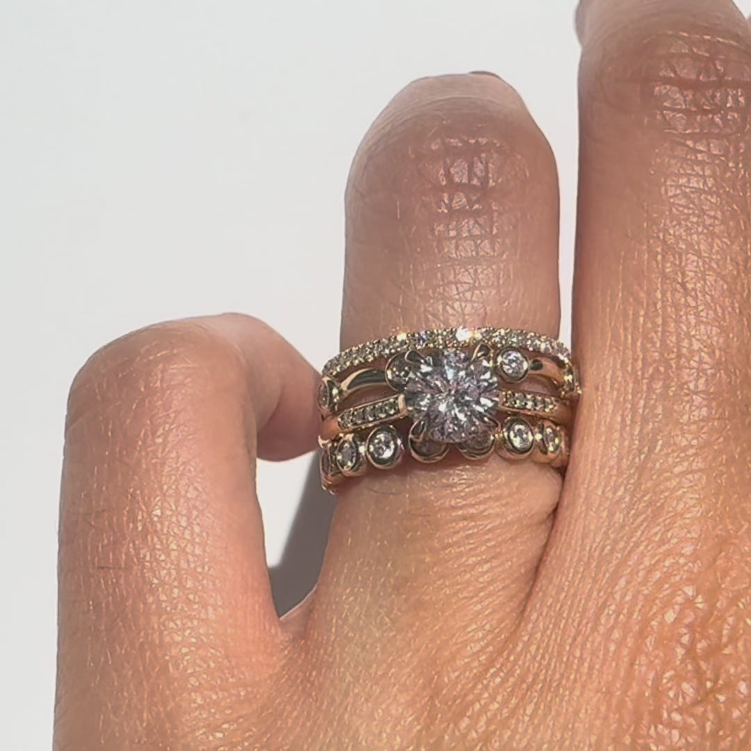 diamond gold rings stacked on a finger against white background