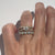 Hand wearing diamond band, diamond engagemeng ring and opal band
