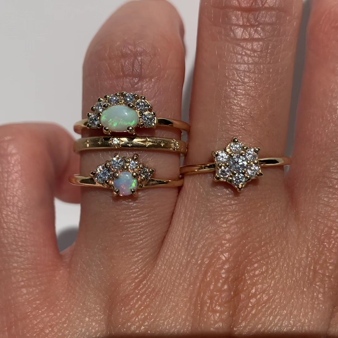 The Opal Diamond Ring features a&nbsp;natural Australian opal&nbsp;set&nbsp;in a half-halo setting. The contoured band is hand-set with an array of baguette and round-cut diamonds to catch the light.